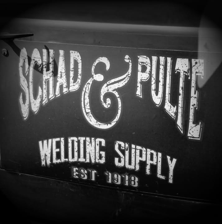 Hand-lettered Schad & Pulte Welding Supply — Est. 1918 sign painted on the door of the shop's antique truck